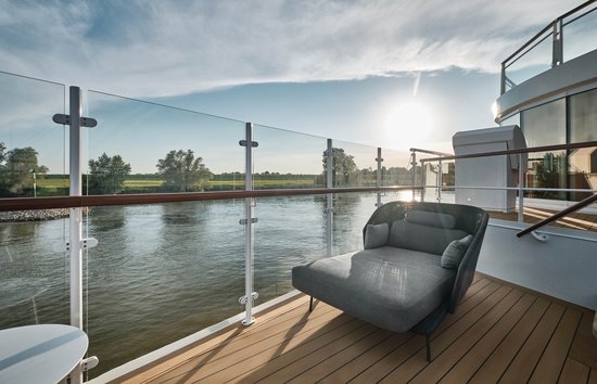 The outdoor area CAPTAINS VIEW at the bow of the A-ROSA SENA with a comfortable chair overlooking the river.