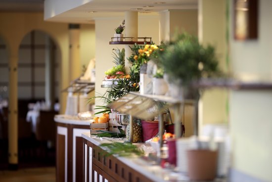 The buffet area on the A-ROSA DONNA with a selection of various dishes, adorned with herbs and fruit.