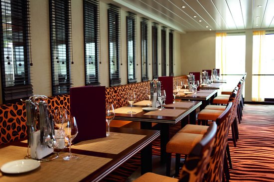 Stylishly set restaurant area of the A-ROSA AQUA and BRAVA with cozy lighting and floor-to-ceiling windows.