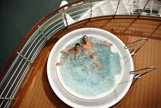 View from above of a couple relaxing in an outdoor hot tub at SPA-ROSA.